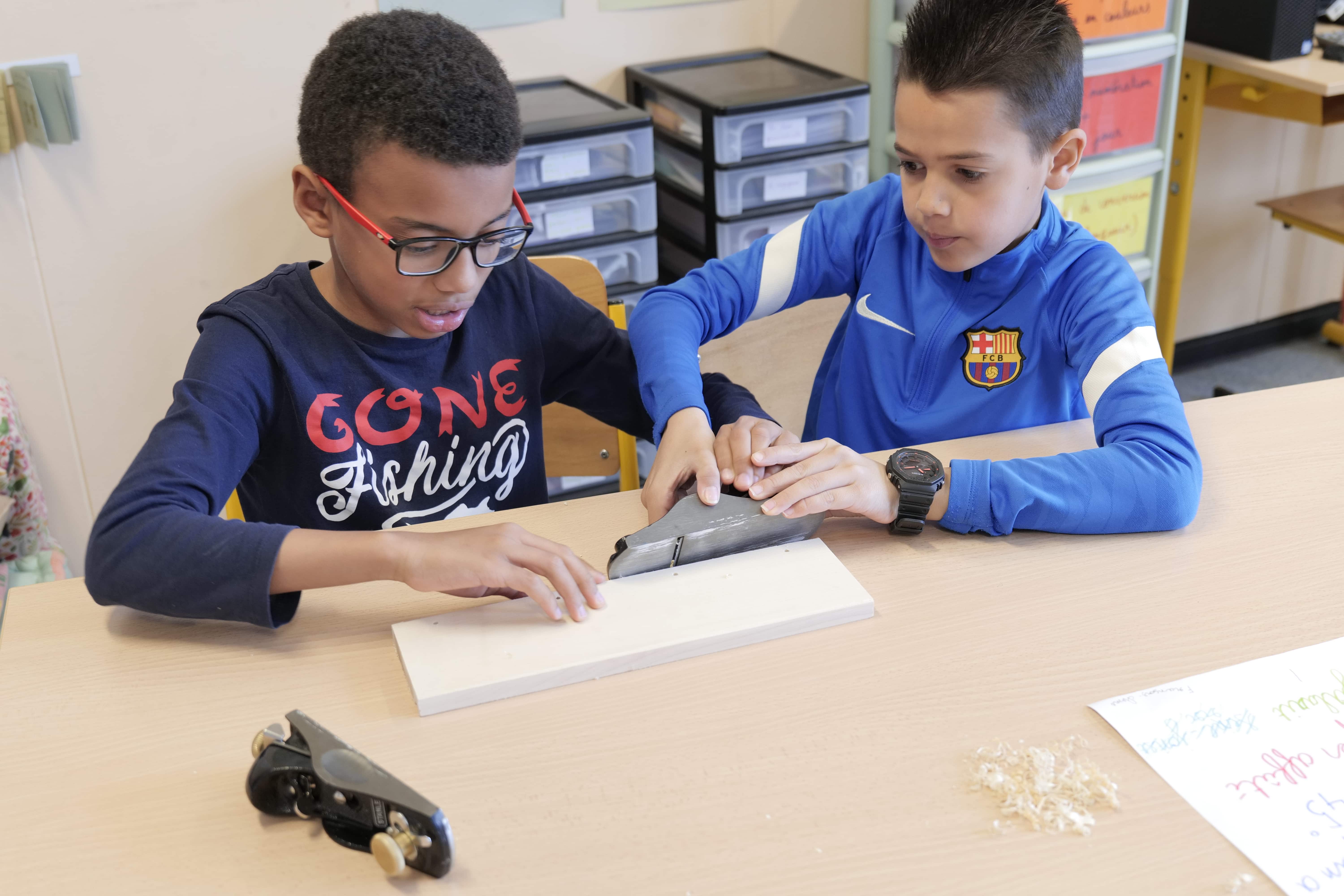 enfants qui découpent du bois