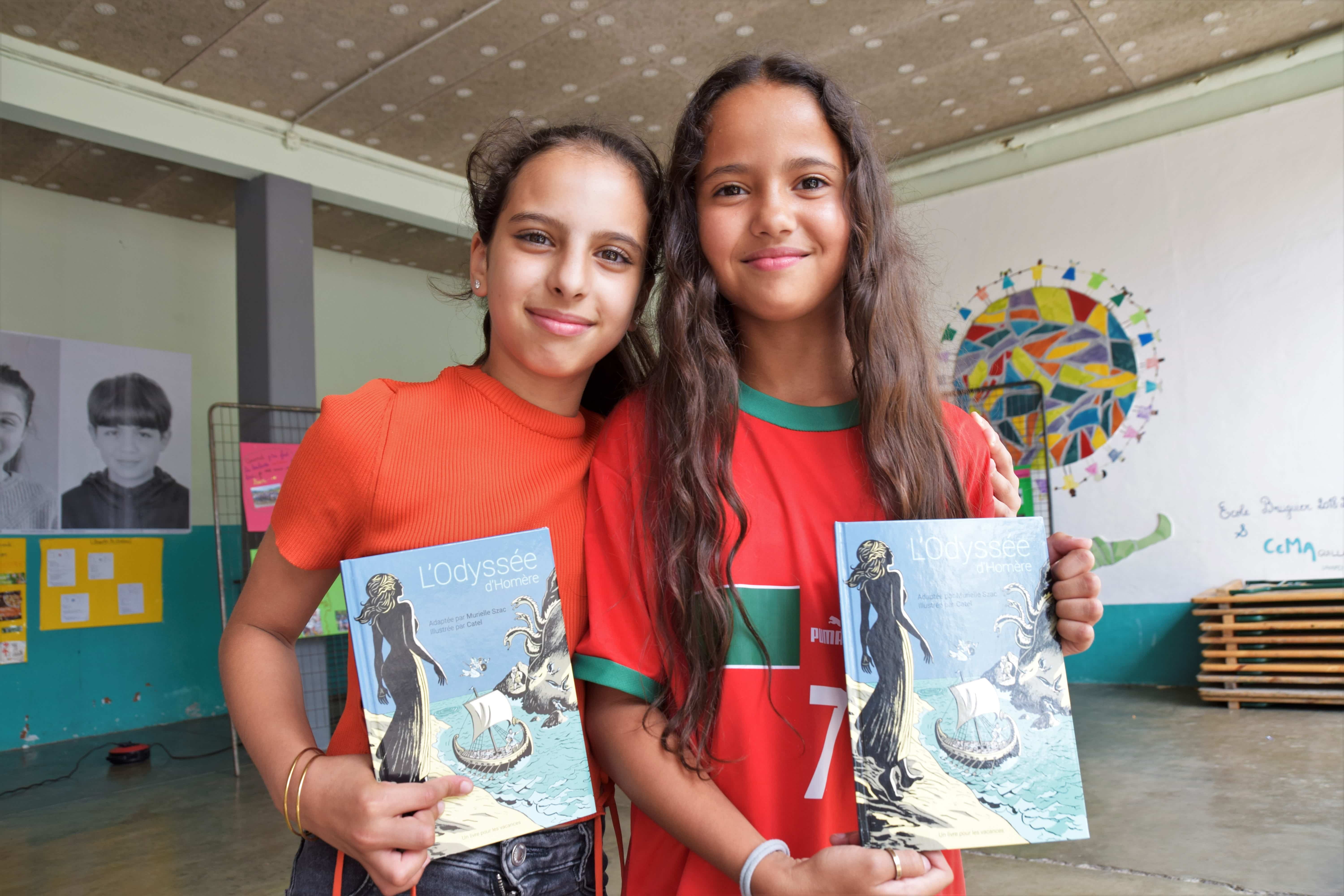 Deux enfants posent avec leur livre