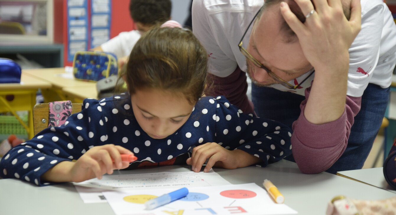 enseignant aidant un élève en classe