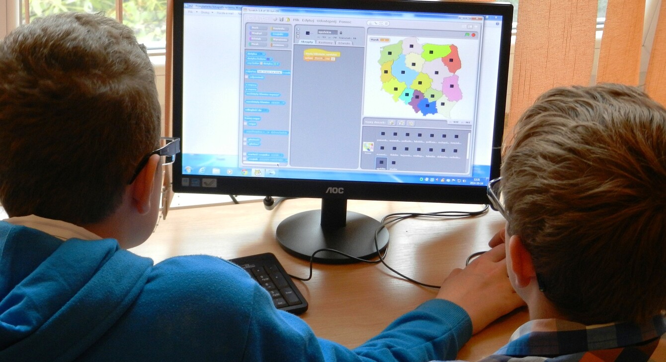Deux élèves sur un ordinateur faisant un programme Scratch