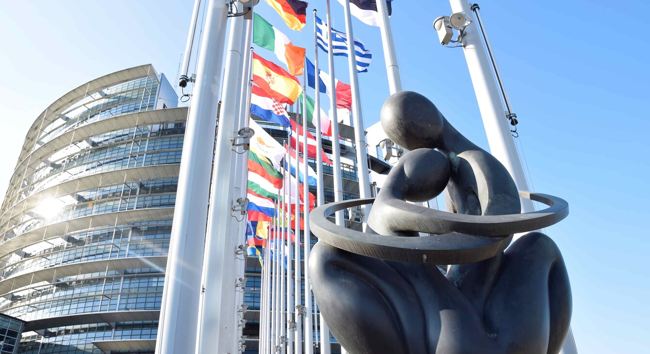 Statue et drapeau devant le parlement européen
