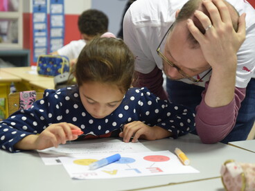 enseignant aidant un élève en classe